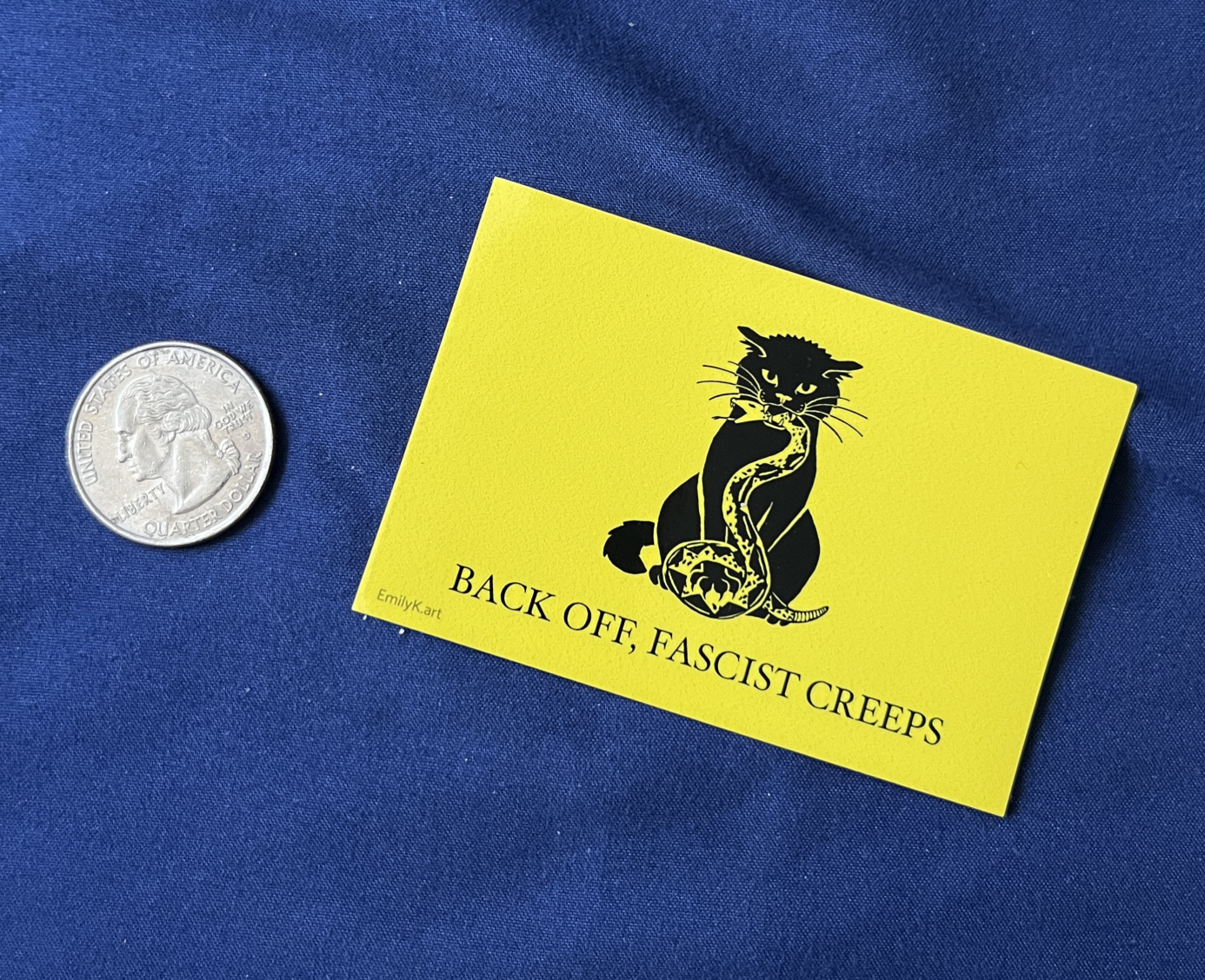 Catsden sticker next to a quarter coin for scale.